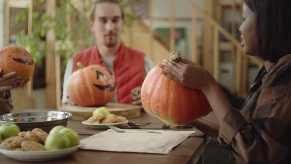 Friends Show to Each Other Their Ready Painted Pumpkins alt
