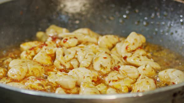 Slow motion of chicken meat fried in a pan with sauce