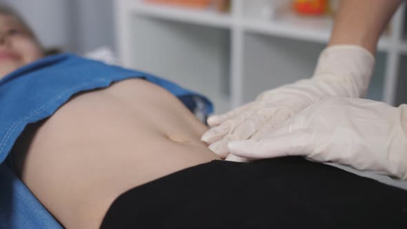 The Doctor Palpated the Abdomen of a Young Patient in a Medical Office alt
