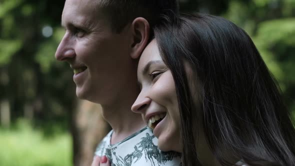 Smiling Brunette Puts Head on Happy Handsome Man Shoulder alt