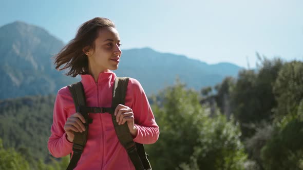 Slow Motion Closeup Portrait of Beautiful Young Woman Hiker Standing on Beautiful Mountain Landscape alt