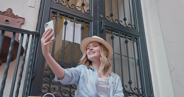 Attractive Young Woman Is Smiling When Making Selfie on Phone. Stylish Traveler alt