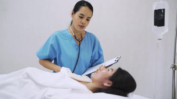 A doctor in hospital use stethoscope check the the lady patient laid on bed