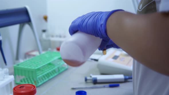 Laboratory Technician in the Laboratory Pours Special Reagents in a Test Tube alt