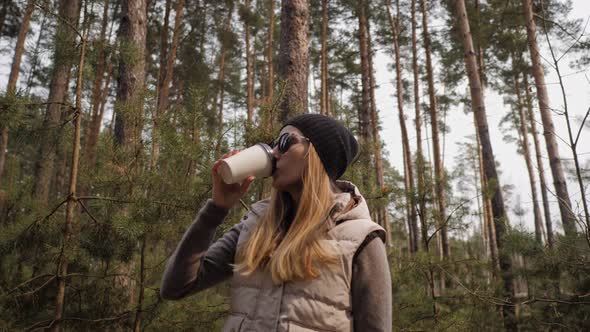 Woman Drink Coffee in the Pine Forest