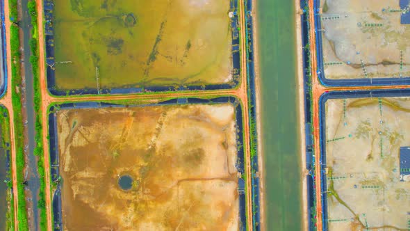 An aerial view over a drone flying over a large shrimp farm alt