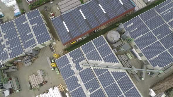 Drone lifting up over industrial roof with solar panels. alt