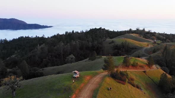 Aerial View Over Lush, Green Nature And Hills, Towards Steep Mountains And Bright Sunlight