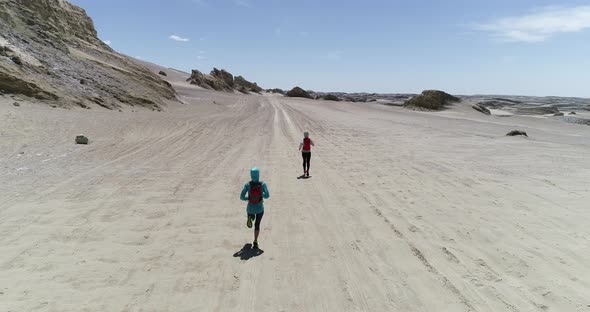 Two women trail runners cross country running in the desert alt