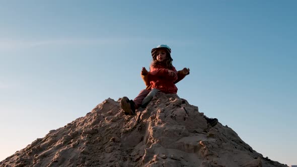 Little Brother and Sister Sit on Large Sand Pile and Play alt