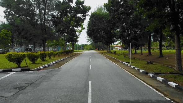 A man exercising and running in the middle of the road captured from above using DJI drone with many alt