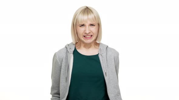 Portrait of Shorthaired Blondie Female 20s Looking on Camera with Disgust on Her Face Expressing alt