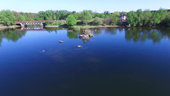 Cyclist looking throught river. Male tourist cyclist standing on shore of lake alt