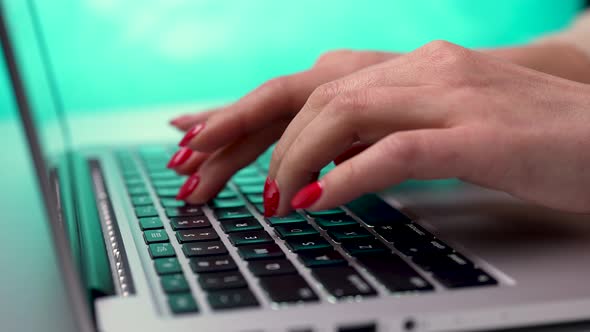 A Freelance Woman Writes a Letter on a Laptop Against the Background of a Blurred Window in Daylight alt