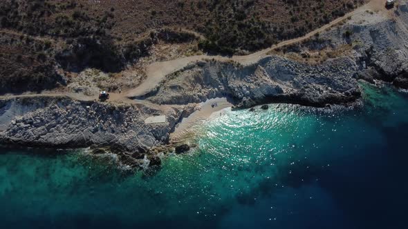 Bird eye view drone shot of Albanian coast in the Mediterranean sea - drone is descending, facing a alt