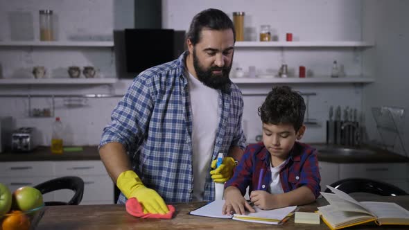 Busy Single Dad Cleaning House While Son Studying alt