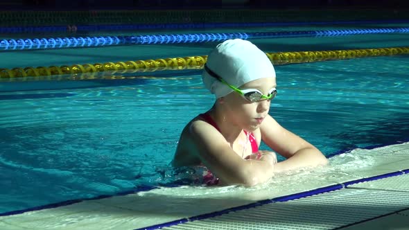 Handsome Young Girl Emerges From Under Water in the Swimming Pool alt