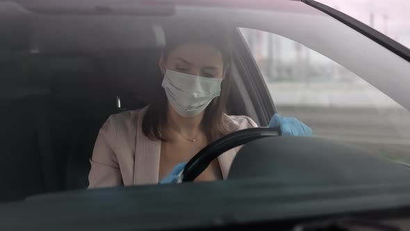 Hypochondriac Woman is Disinfecting Steering Wheel of Her Auto Fear of Infection alt
