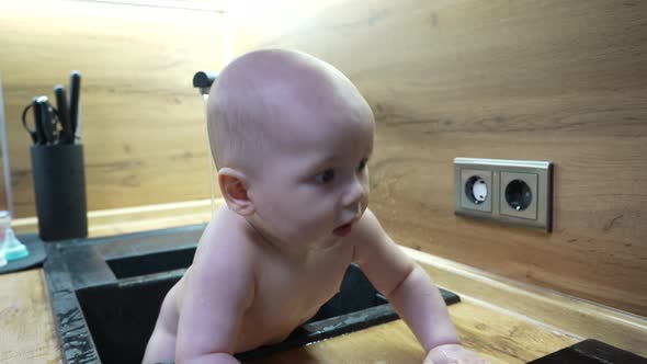 Baby in Kitchen Sink Bathing and Playing with Water