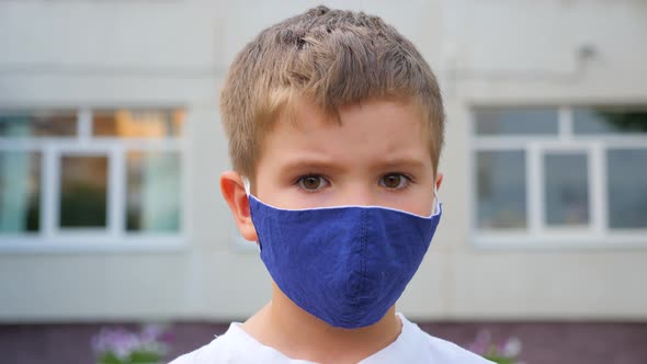 Face Mask for Protection Coronavirus Outbreak. Child Wearing a Medicine Mask Outdoors. Coronavirus