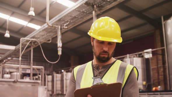 Worker examining while writing on clipboard alt
