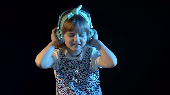 Futuristic Hipster Teen Girl Listening Music in Headphones Dancing in Neon Lights at Disco Club alt