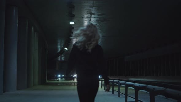 Female Person Night Walk at Highway Wearing Urban Clothes in Driving Tunnnel alt