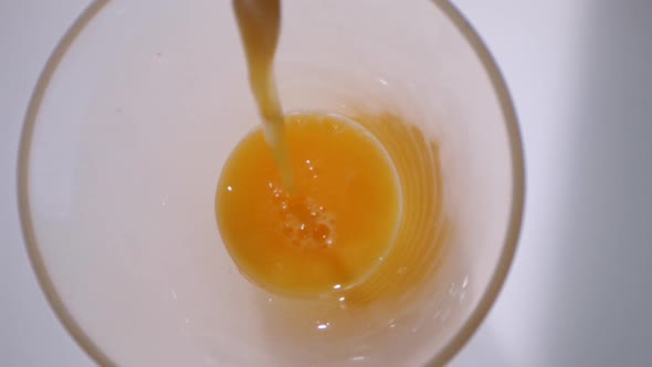 Pouring Orange Juice on A Glass