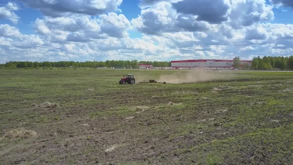 Tractor Operates on Field Birds Peck Grain on Sunny Day alt