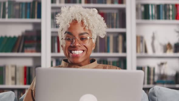 Young African American Woman with Laptop on Lap Overjoyed Winning Competition alt