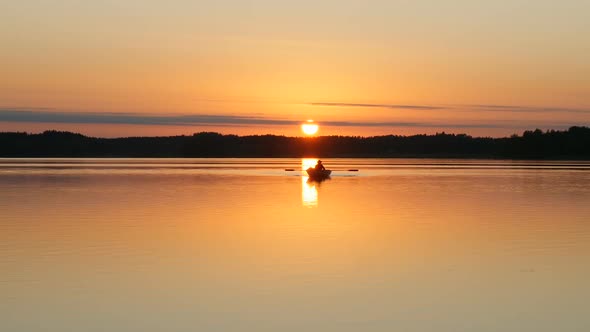 Beautiful Sunset Over Lake and Fisherman on Boat
