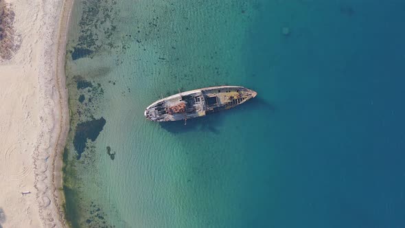 A Wrecked Wooden Ship Lies on the Seashore Covered with Rust alt