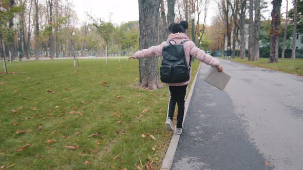 Back View Schoolgirl Walk on Curb Little Girl with Black Backpack Keep Balance Child Going to School alt