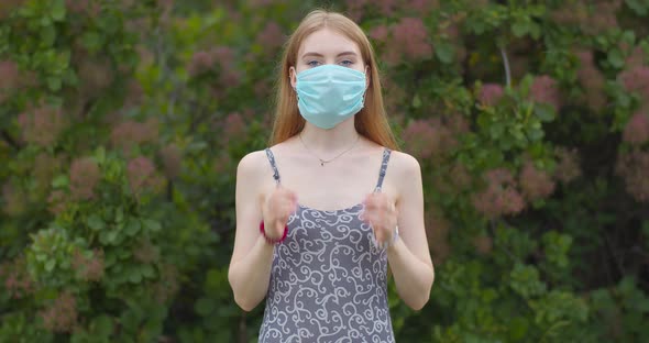 Beautiful young blonde girl takes off a medical mask