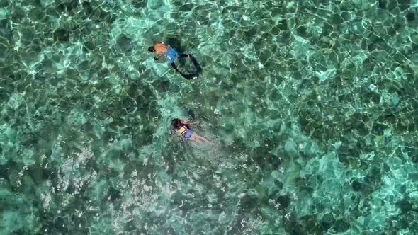 Aerial view of two people snorkeling with turtle in Panagsama Beach, Philippines. alt