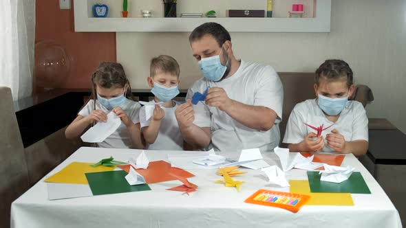 A Father with Children in Medical Masks Makes Paper Planes and Launches Them Indoors