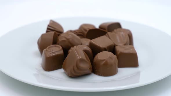 Chocolate candies on a white plate alt