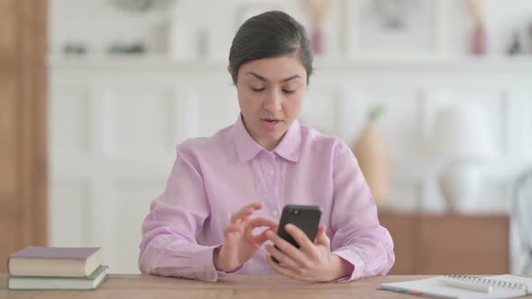 Successful Indian Woman Celebrating on Smartphone alt