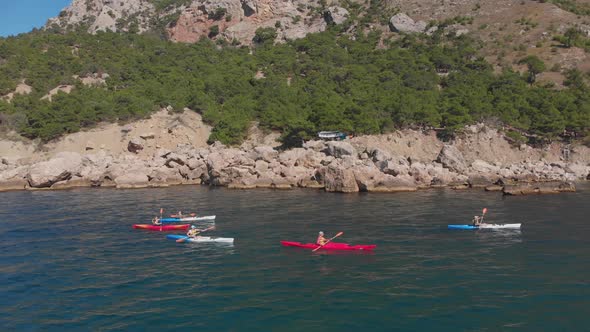Aerial Shot Group of Kayakers Paddling Down on Mountain River on Kayaks on Summer Day alt