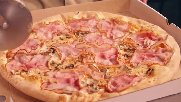 Pizza cutter cuts pizza with a round knife alt