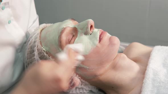 The Cosmetologist Removes the Natural Clay From the Man's Face with a Napkin