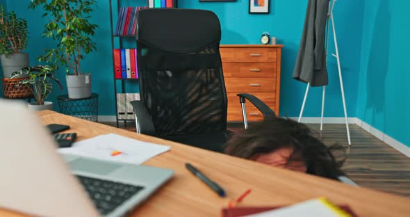 Funny Comical Man with Round Thick Glasses Disheveled Hair Leans Out From Under Desk in alt