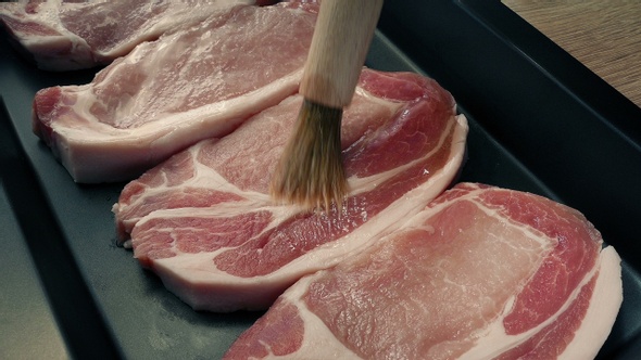 Brushing Oil On Pork Chops For Cooking alt