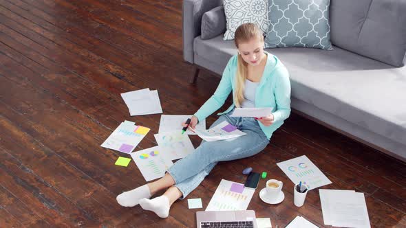 Young woman works with documents using a laptop at home. alt