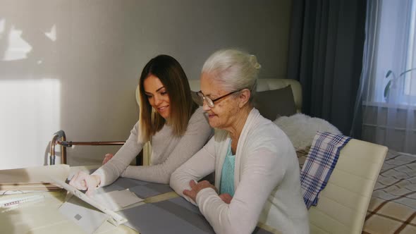 Young Woman Watching Family Photos with Grandma