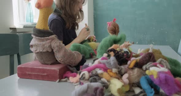 Woman Making Wool Art Doll Toy at Table. Female Sitting and Creating Ooak Doll at Home. Needle alt