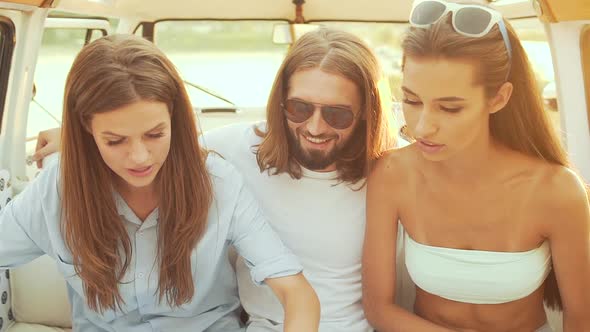 People Using Map Traveling In Summer. Smiling Happy Young Friends Using Map. alt