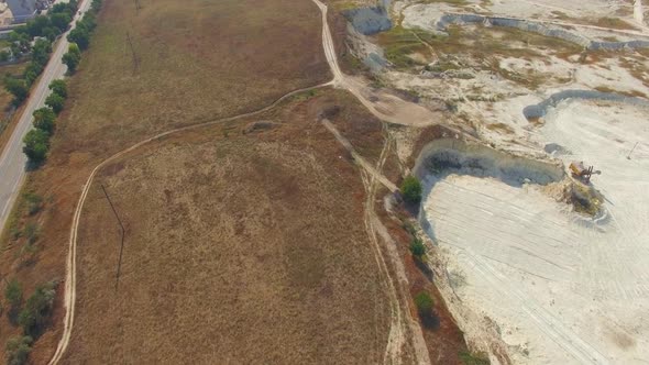 Quadrocopter Flies Over Field and Quarry