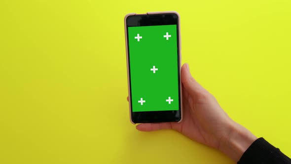 Woman watching content videos on green screen smartphone alt