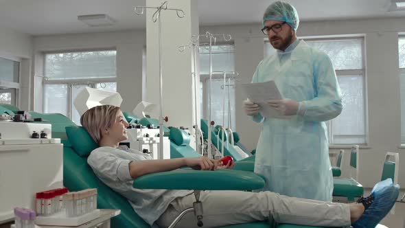 Doctor Explaining Terms of Blood Donor Agreement alt